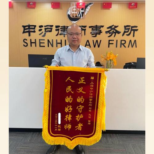 上海律师事务所内锦旗和案卷堆积的办公场景