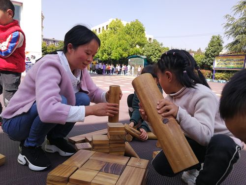 老师蹲在地上和孩子一起搭积木