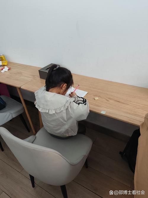 教室后排学生趴在桌上抄写罚写作业的场景