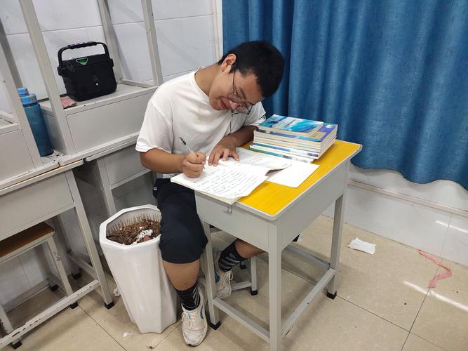 青年坐在书桌前记录日常作息的真实生活图