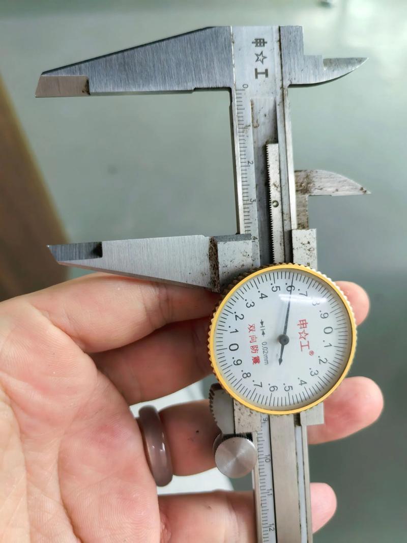 工匠使用一把1958年上海产游标卡尺测量零件