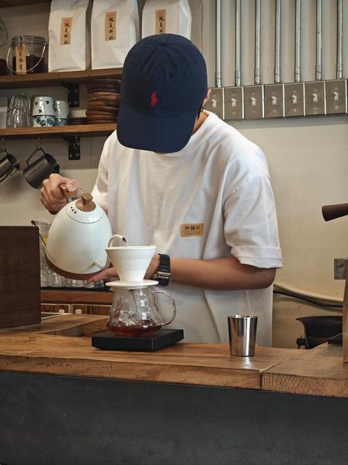 咖啡师在日式简约吧台后专注手冲咖啡