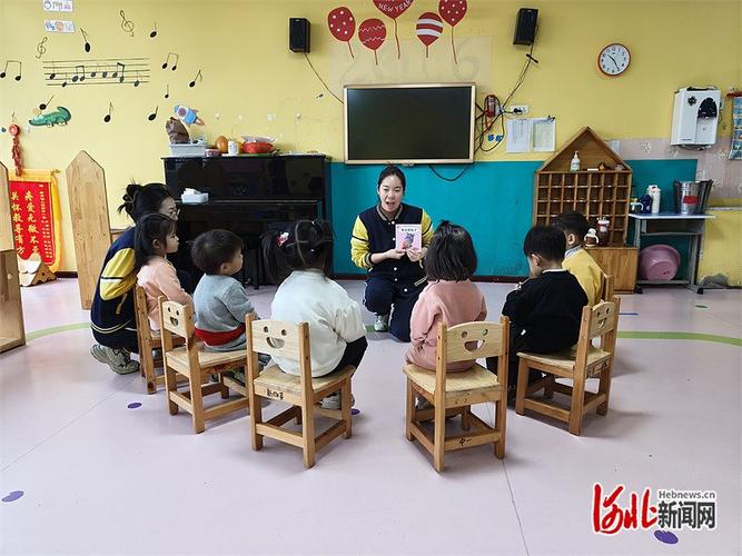 幼儿园老师用大绘本给围坐的孩子们讲故事