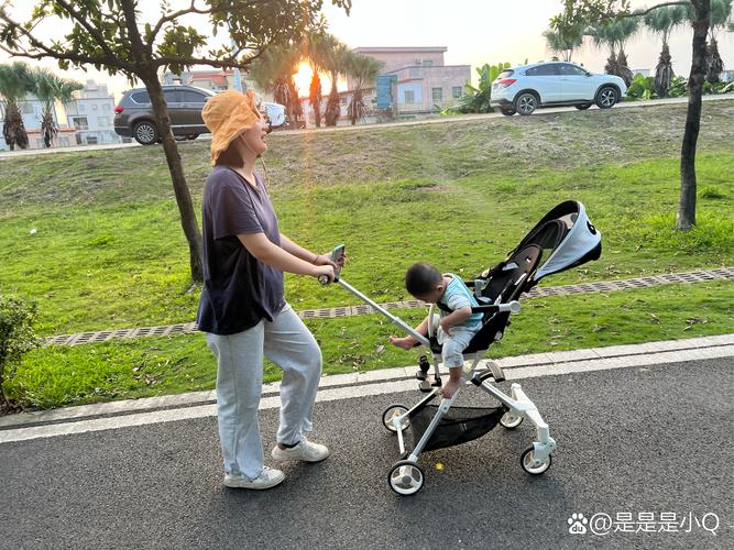 婴儿车在公园平坦塑胶步道推行实景