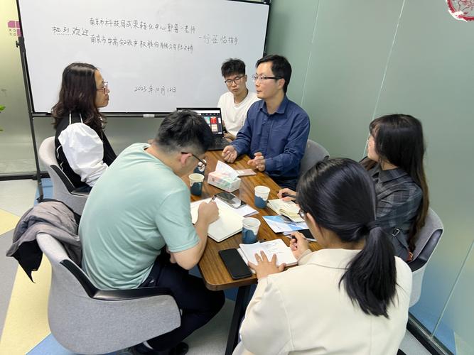 技术经理人在实验室内与教授和企业代表三方讨论