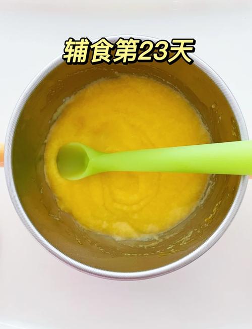 8月龄宝宝坐在木质餐椅上抓短柄硅胶勺舀南瓜泥的实拍图