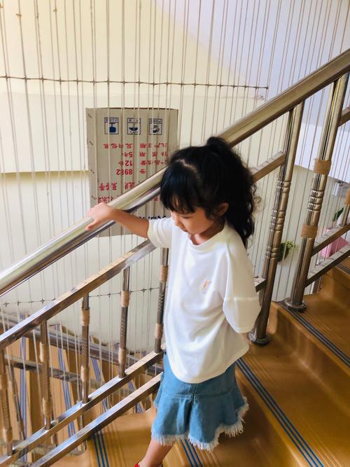 小朋友在居民楼楼梯上数台阶的生活场景
