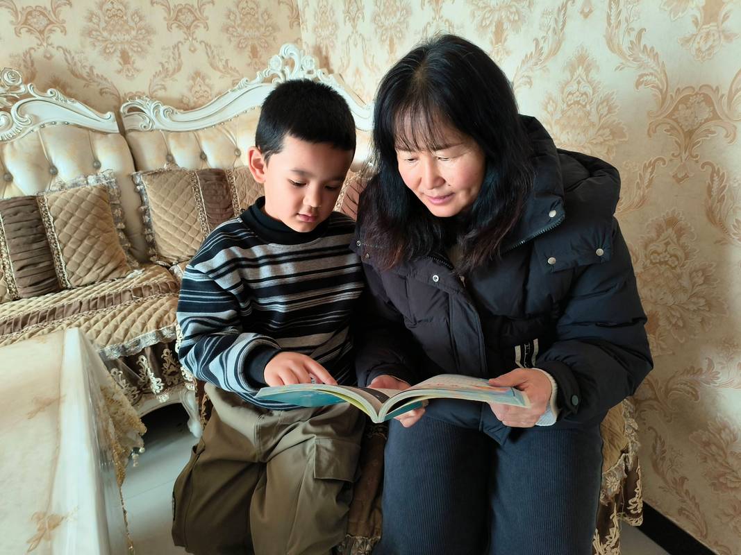 老师坐在学生床边 倾听孩子拉家常