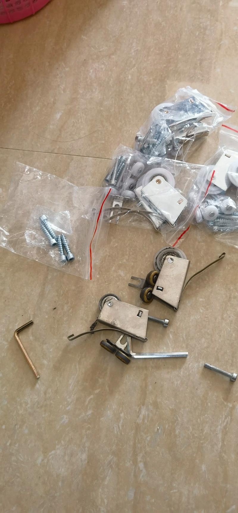 装修工正在用工具调整折叠门滑轮高度