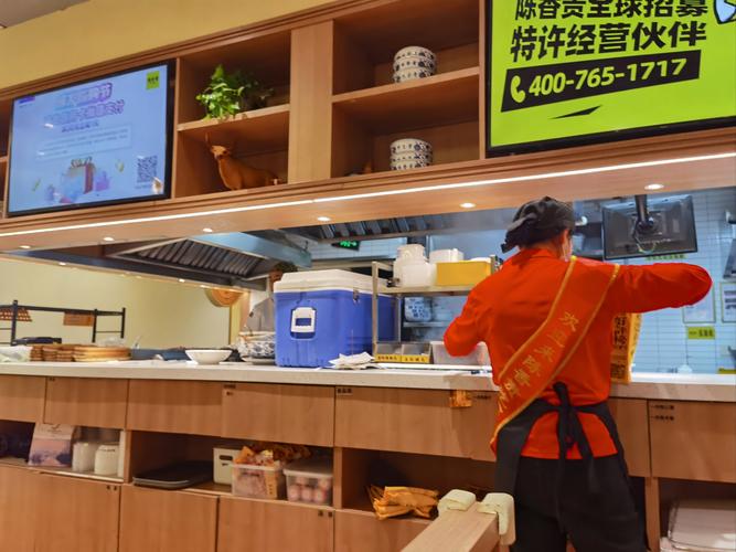 南京巷口小吃店老板操作手机运营后台图