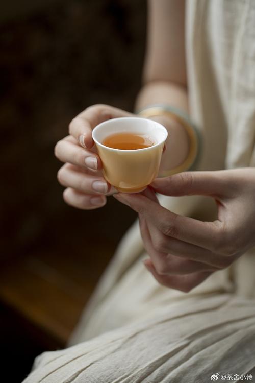 女性手捧白色茶杯闻花草茶香气特写场景