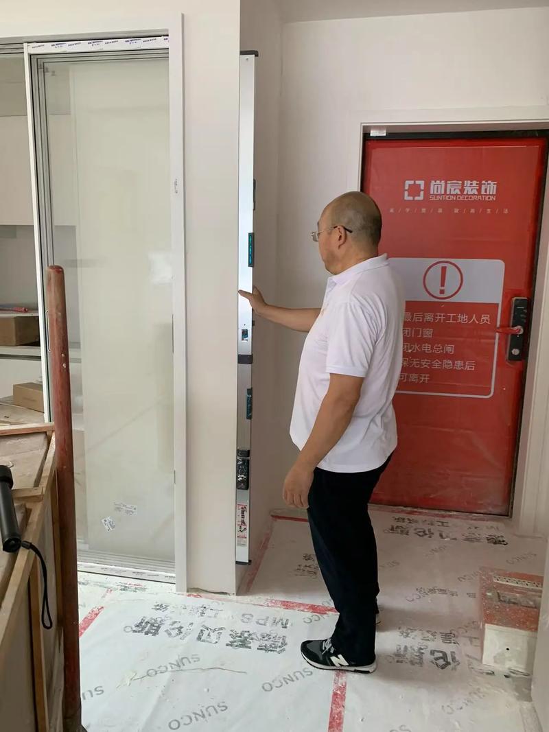 装修师傅用强光手电筒和靠尺验收墙面平整度