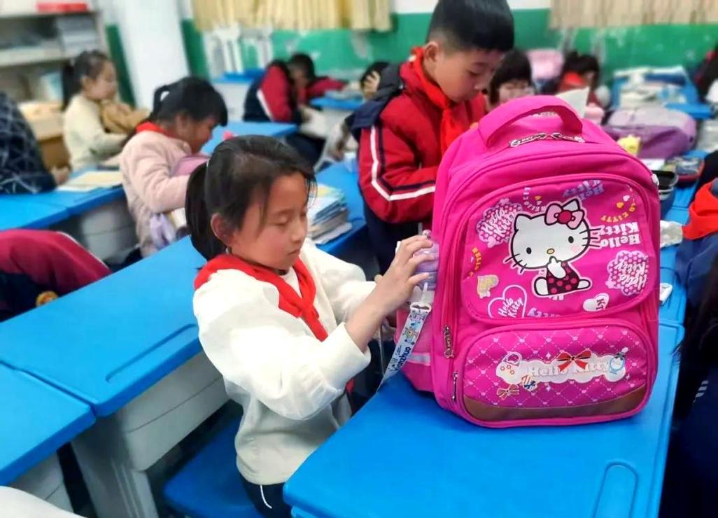 乡村小学学生携带布袋和餐具上学