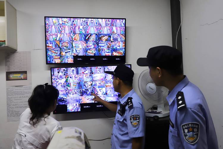 侦查人员查看监控录像调查犯罪现场