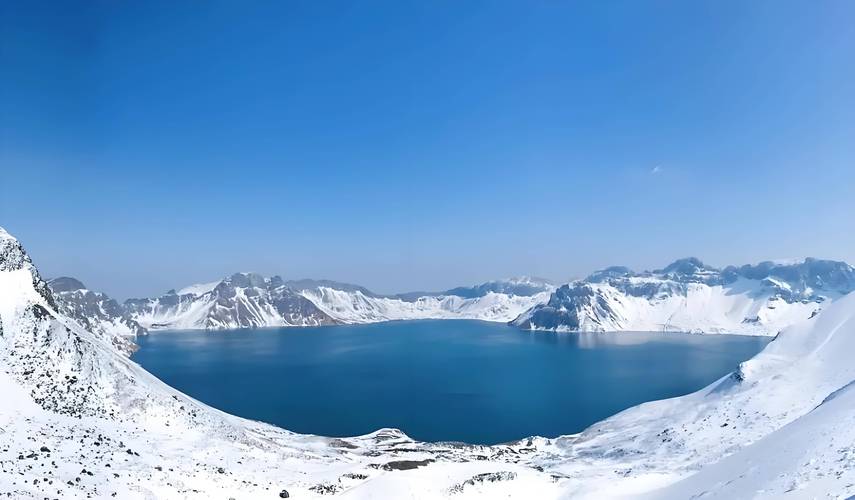 长白山天池主峰黑褐色火山岩环绕澄澈蓝色湖面