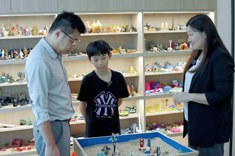 学校心理咨询室老师与学生进行沙盘游戏治疗场景
