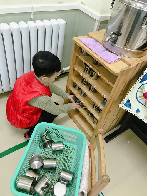 幼儿摆放自己的小水杯到固定位置实拍图