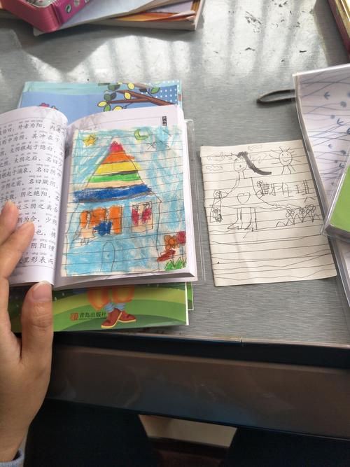 乡村木书桌上留守儿童画满牵手的日记本