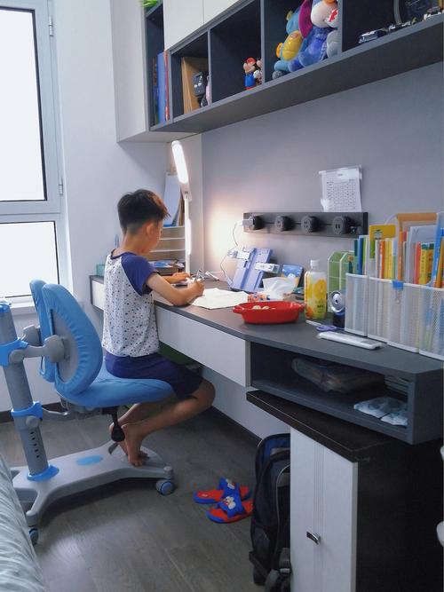 客厅书桌前小学孩子自主写作业日常场景