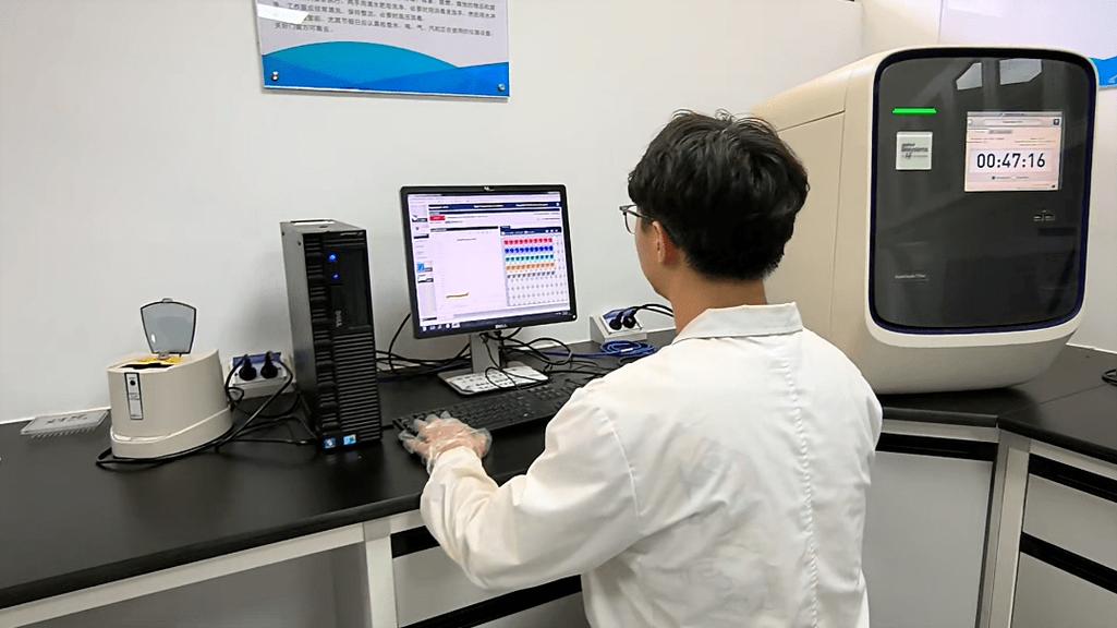 科研人员在电脑前使用AI学术助理软件整理文献
