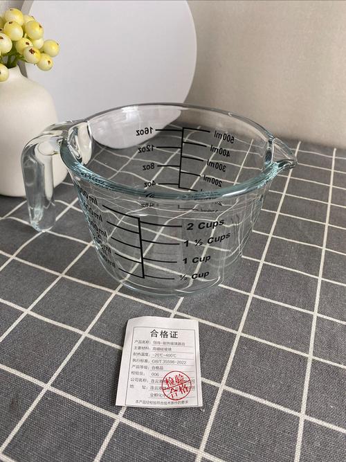 标注150ml刻度的透明玻璃杯放在卧室床头柜的实拍图