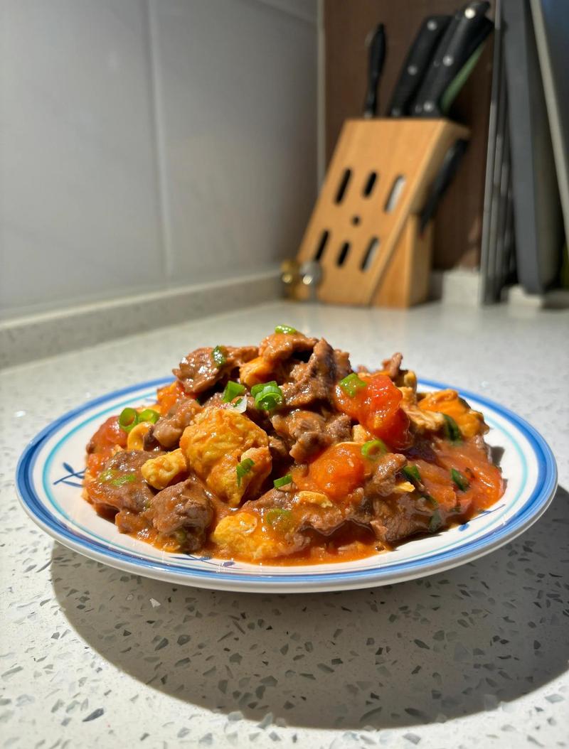 家常番茄炒瘦牛肉盛在白瓷盘里