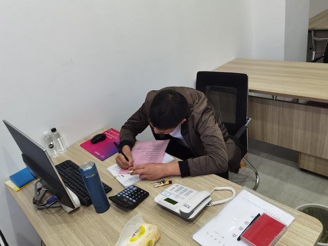 应届生坐在工位上拿着劳动合同仔细核对的实拍