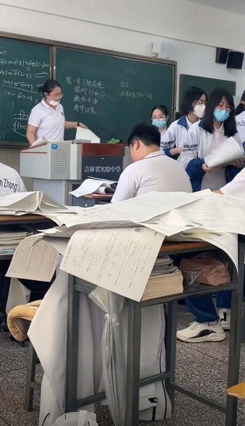 高三教室堆放在课桌上的模考试卷图