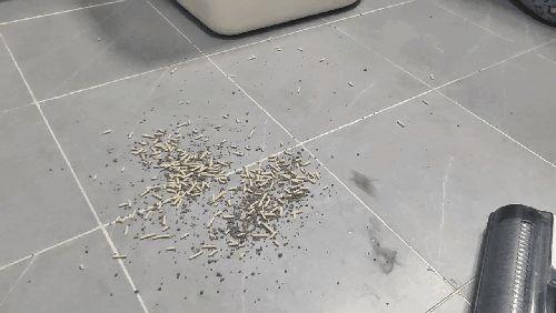 浅色木质地板上散落的浅灰色猫砂颗粒