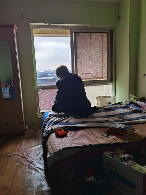 工业区宿舍窗边独坐的男性工人