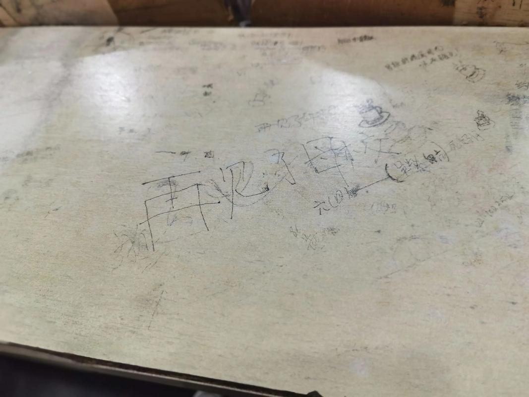 教室木质课桌上的随手文字涂鸦
