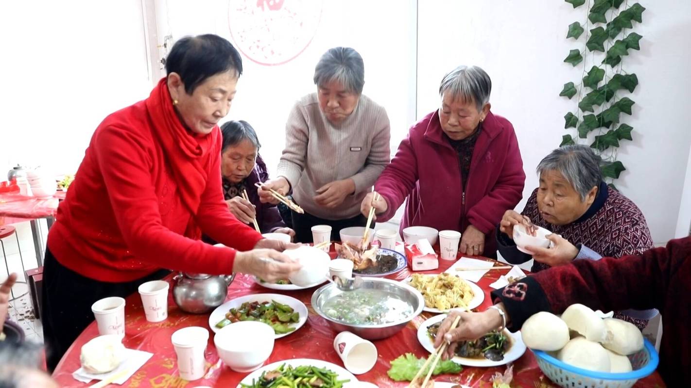 中式家庭聚餐长辈给晚辈夹菜场景图