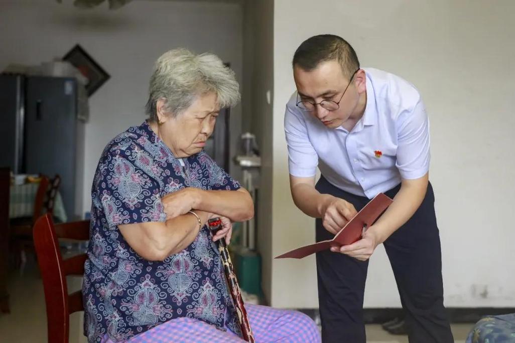 社区法律咨询点老人攥着房产证跟工作人员交流的场景