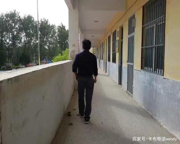 中学教师课间走廊靠墙休息背影