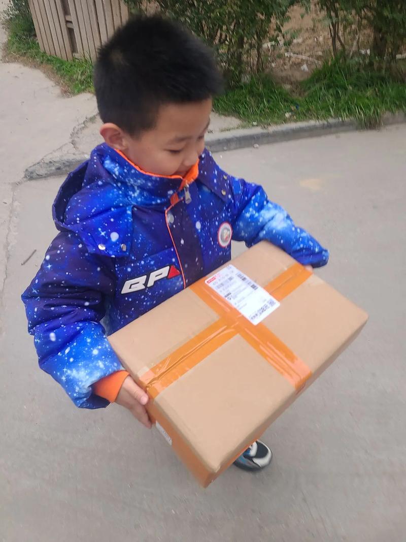 小区快递柜旁小朋友抱空纸箱回家