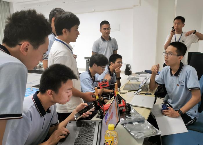 高中生在学校社团实验室进行机器人搭建和编程的场景