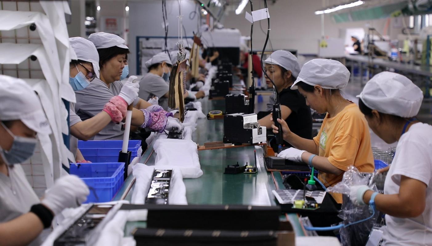 制造业女工在车间休息区刷育儿手机