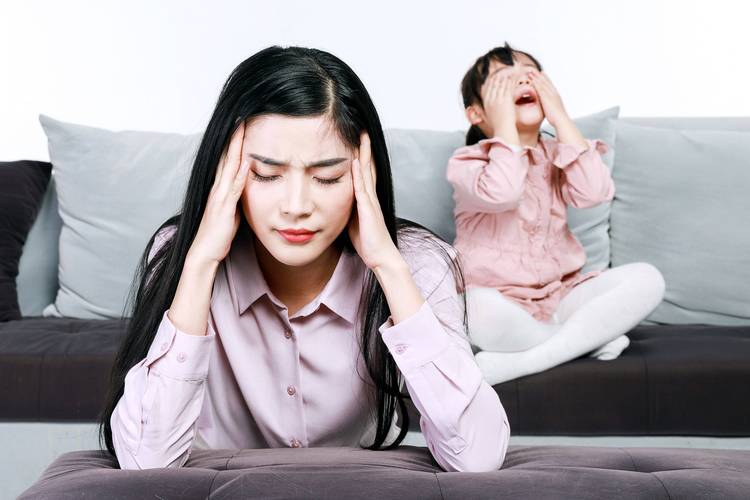 一位母亲看着朋友圈里完美育儿照片焦虑的表情特写