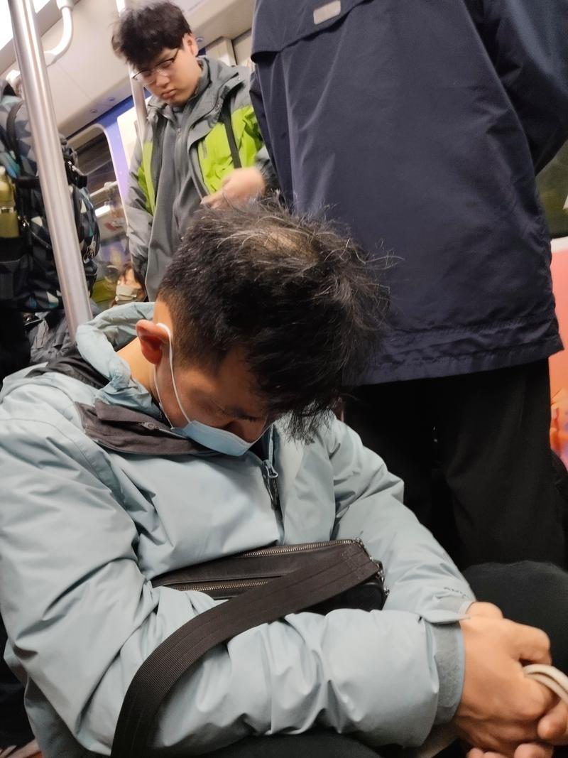 上班族地铁通勤靠在扶手上发呆的实拍