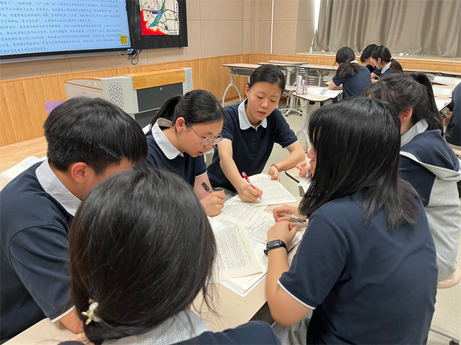 中学教室里学生小组友善互助记笔记场景
