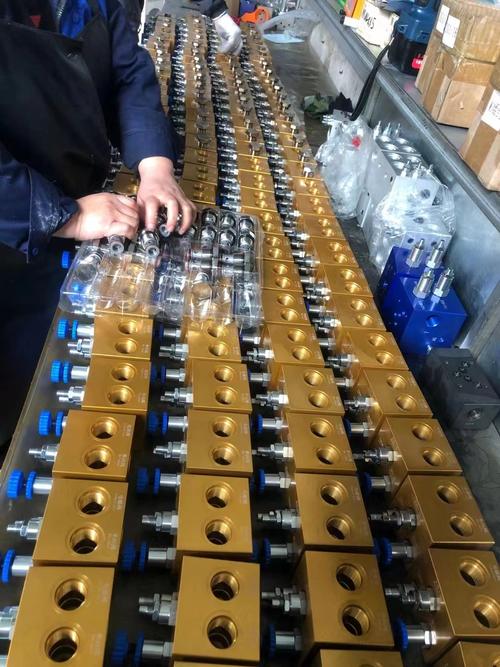 机加工车间工人手持改进前后液压阀块对比实物