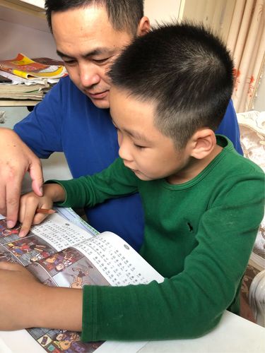 制造业爸爸下班回家陪孩子读故事照片