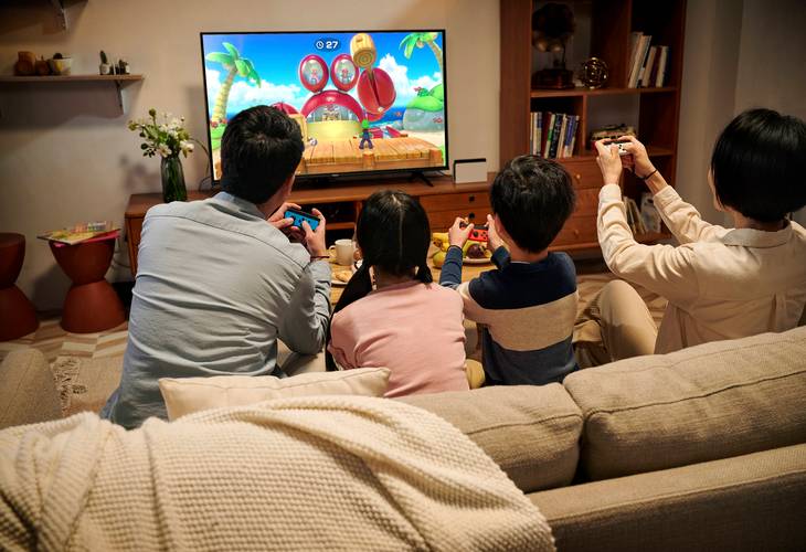 客厅沙发上多人玩Switch游戏场景
