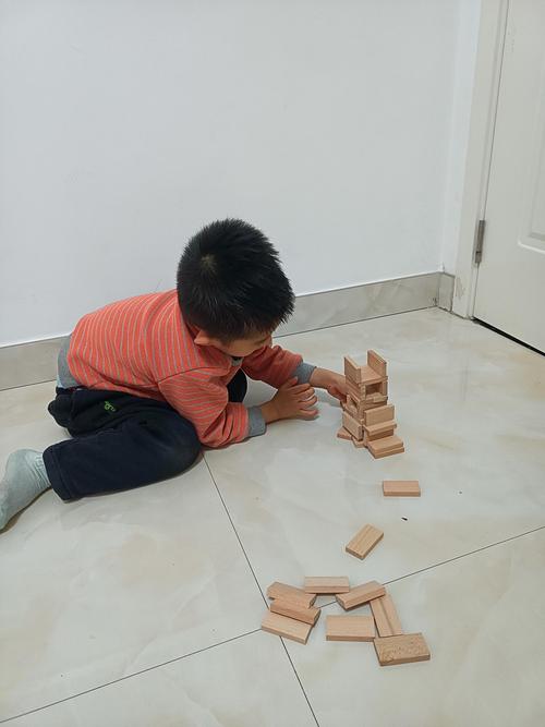 幼儿积木塔塌掉后委屈蹲坐的场景