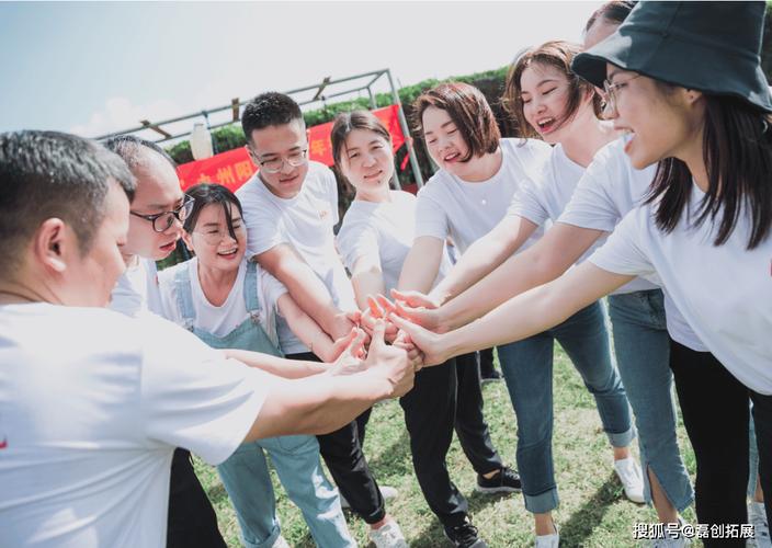 穿统一文化衫的员工在团建场地配合教练摆拍