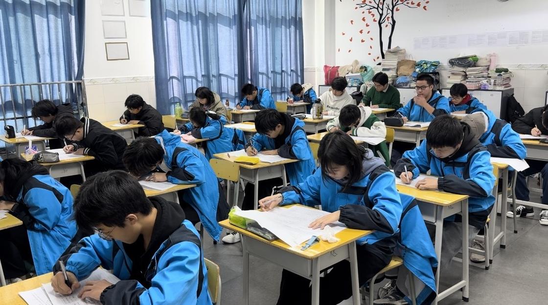 中学教室自习课上学生捏断圆珠笔的特写