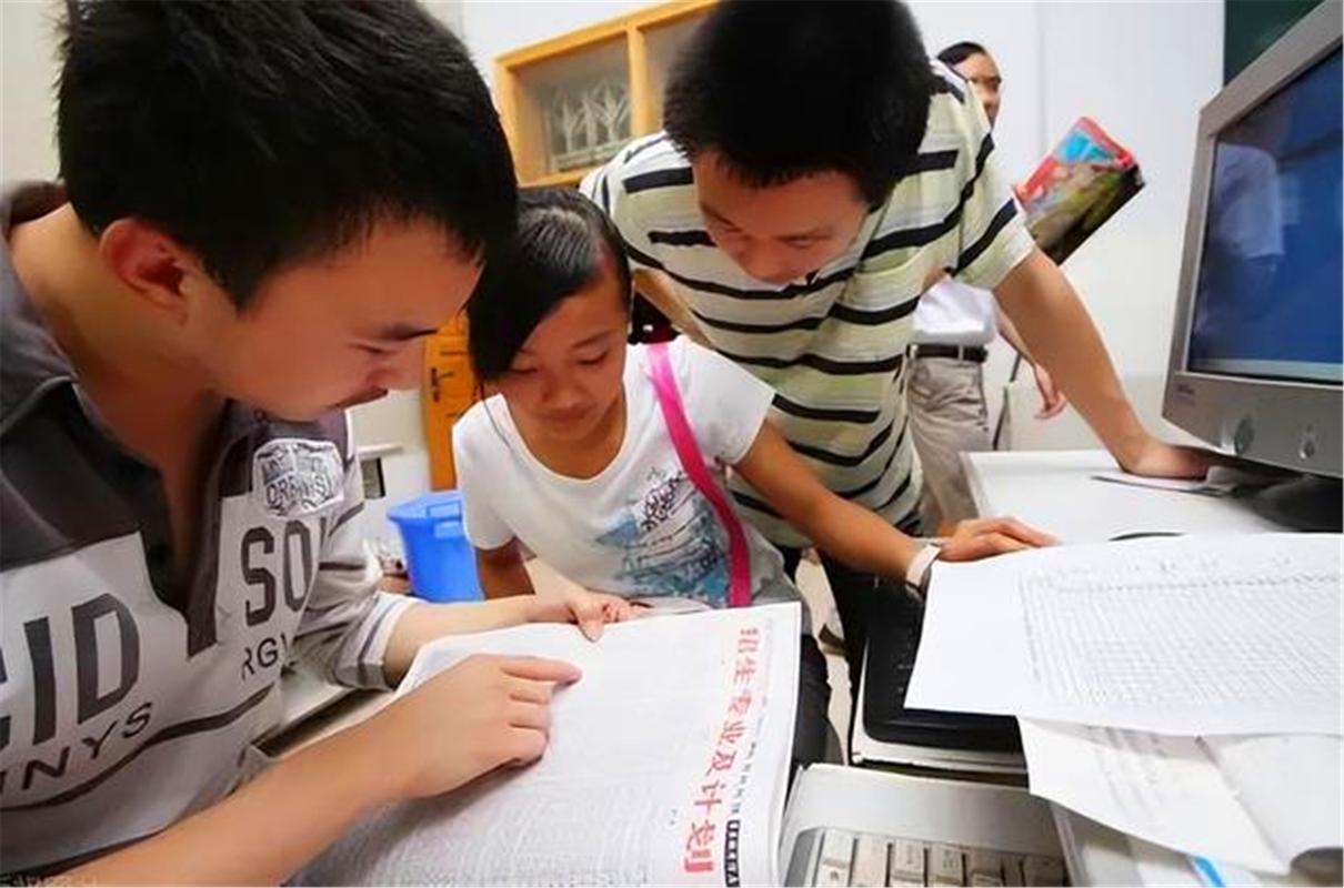 新高考志愿填报考生和家长对着电脑讨论的实拍图