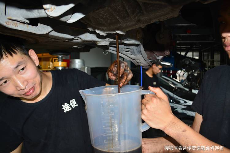 汽修技师举着手电筒检查双离合变速箱油状态