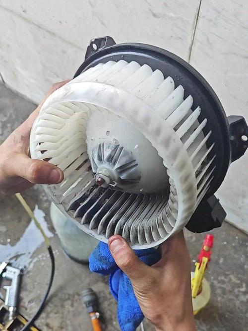 汽修技师拆开汽车空调鼓风机外壳展示内部积尘
