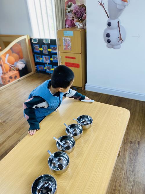 3岁孩子自主选勺子的餐桌场景